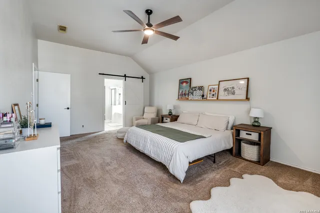 a spacious bedroom with a bed and a chandelier