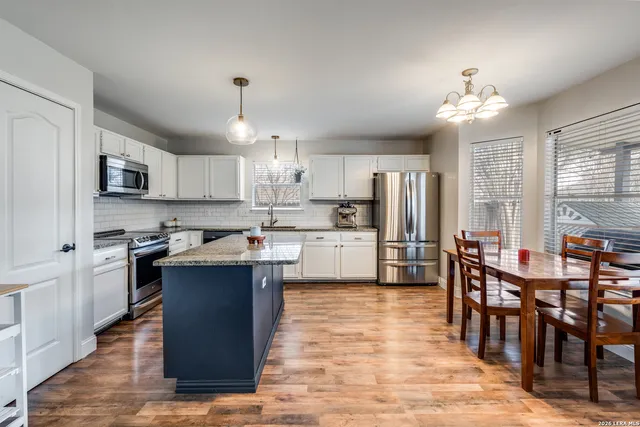 a kitchen with kitchen island granite countertop a sink center island and stainless steel appliances