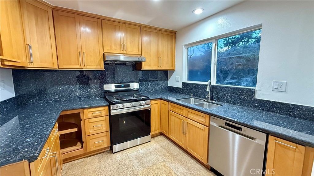 13434 Randsburg Street Cerritos, CA 90703 - Photo 5 of 13 a kitchen with granite countertop wooden cabinets stainless steel appliances and a window