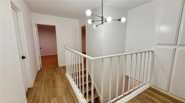a view of a hallway with wooden floor and staircase