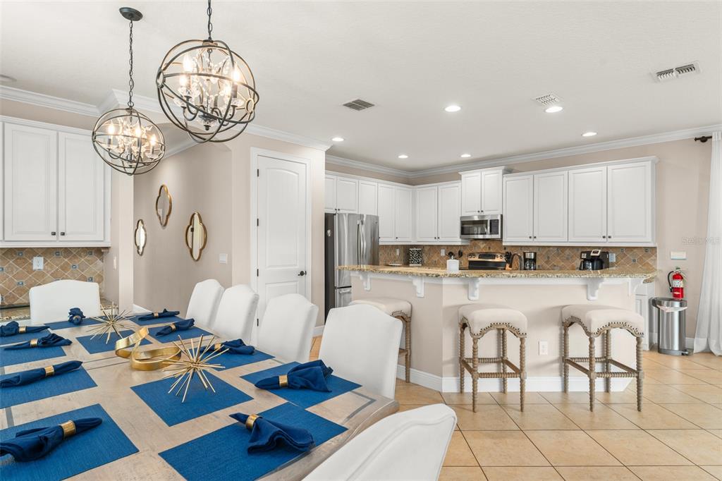 717 Desert Mountain Court Reunion, FL 34747 - Photo 15 of 62 a living room with furniture a chandelier and kitchen view