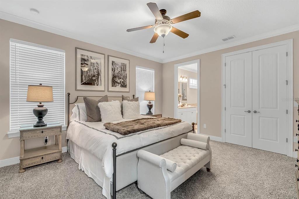 717 Desert Mountain Court Reunion, FL 34747 - Photo 26 of 62 a bedroom with a bed and a chandelier