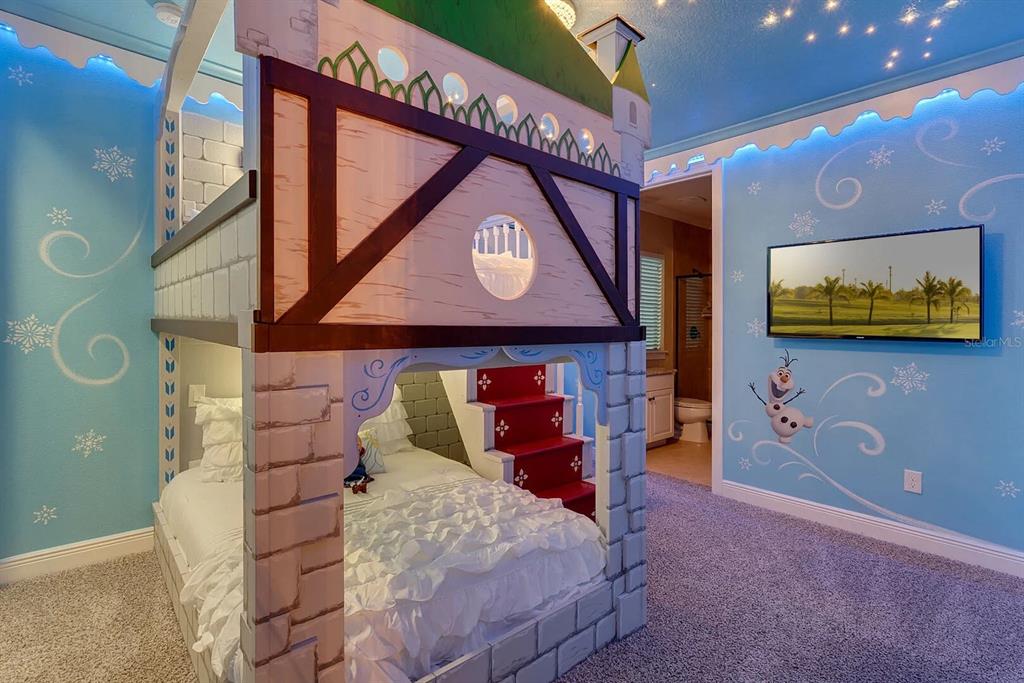 717 Desert Mountain Court Reunion, FL 34747 - Photo 31 of 62 a bedroom with a bed and a tv on the wall