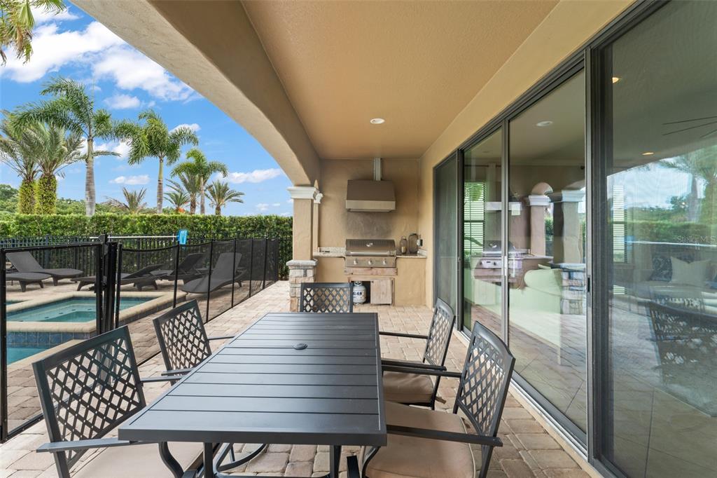 717 Desert Mountain Court Reunion, FL 34747 - Photo 61 of 62 a view of a patio with dining table and chairs with wooden floor