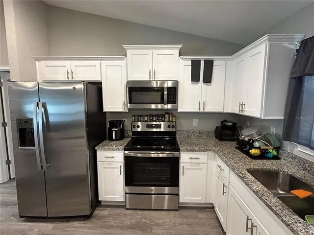 a kitchen with a refrigerator stove and microwave