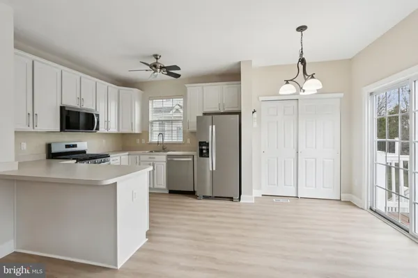 a kitchen with stainless steel appliances granite countertop a refrigerator a stove a sink and a wooden floors