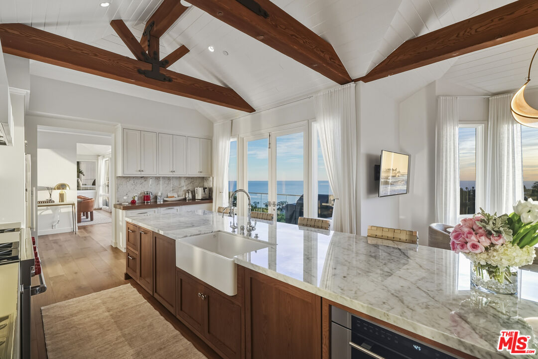 3140 Sweetwater Mesa Road Malibu, CA 90265 - Photo 18 of 71 a large kitchen with stainless steel appliances a sink and cabinets