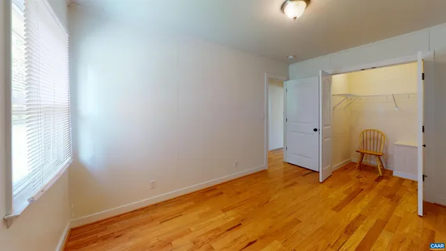 a view of a room with wooden floor and a window