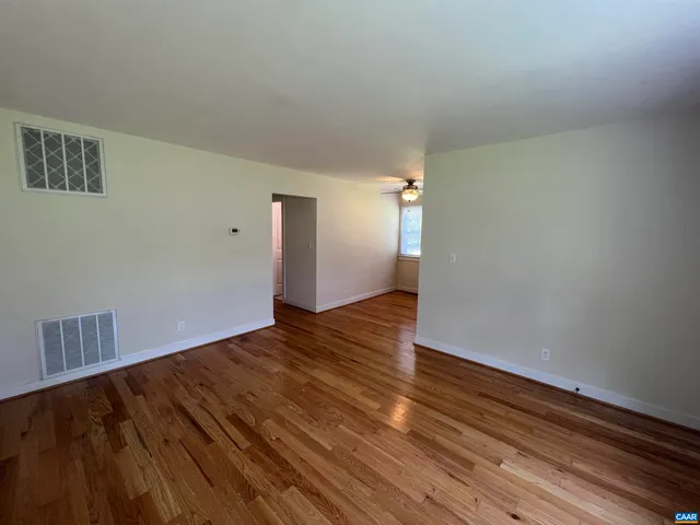 a view of an empty room and wooden floor