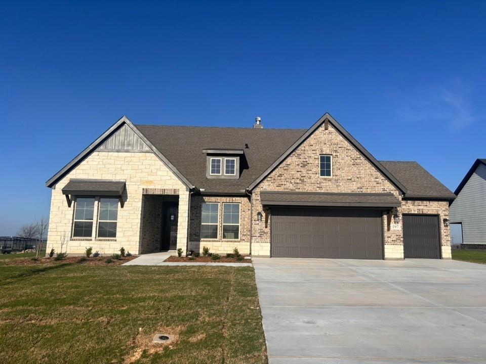 a front view of a house with a garden and yard