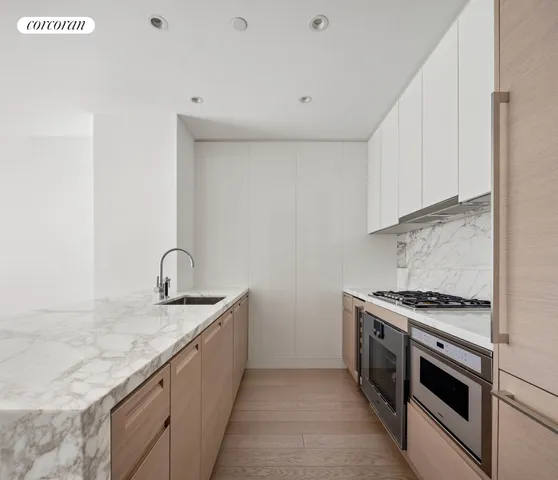 a living room with furniture potted plant wooden floor and a large window