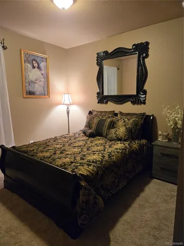 a bedroom with a bed and a potted plant on dresser