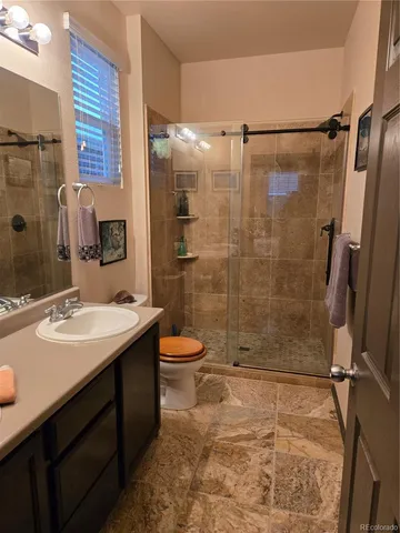 a bathroom with a sink shower and a mirror