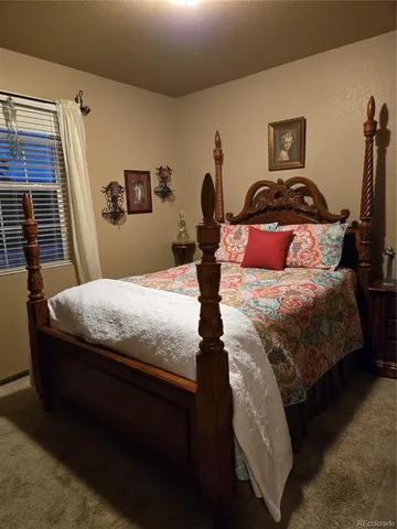 a bedroom with a bed and a lamp on the dresser