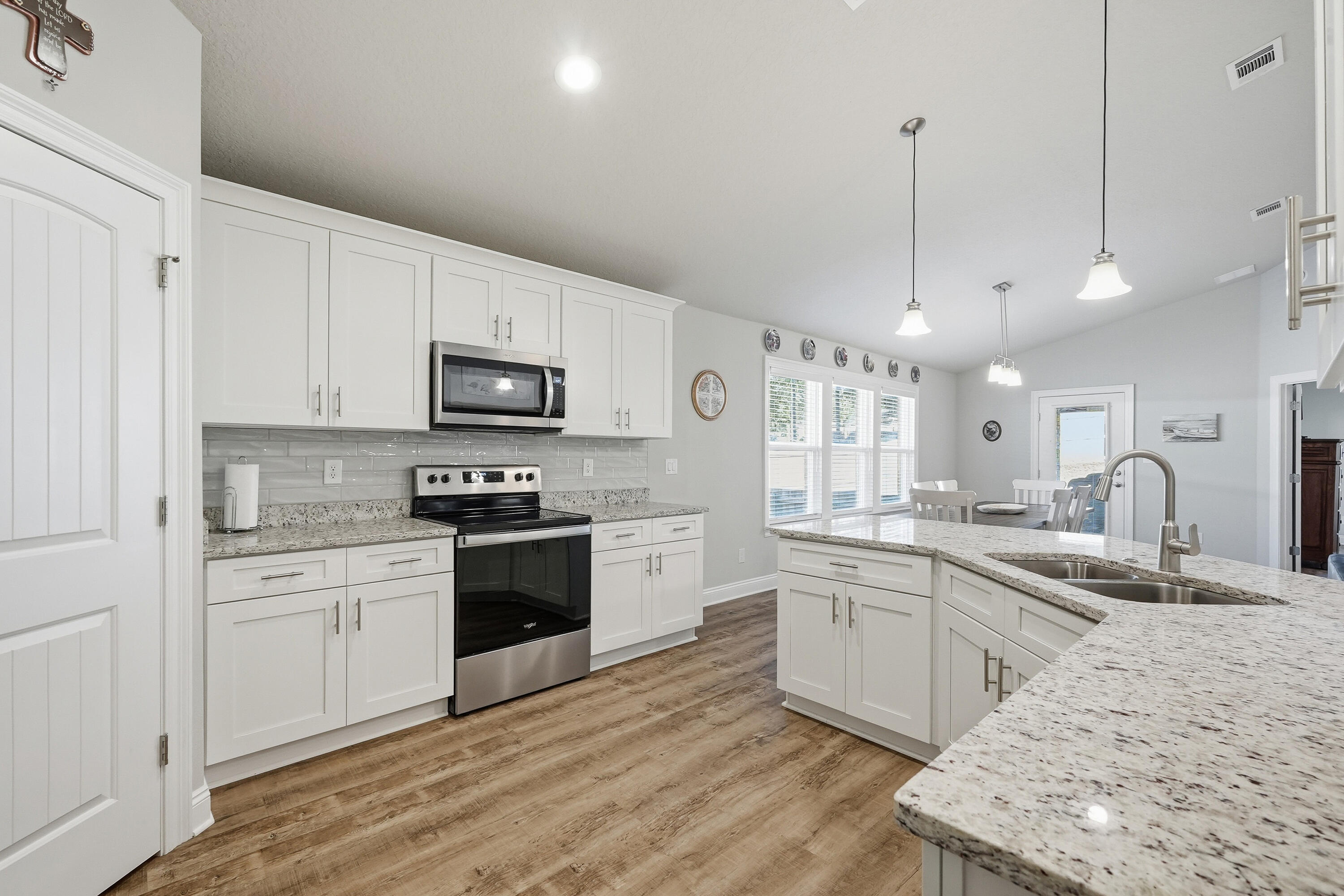 7434 Gordon Evans Road Navarre, FL 32566 - Photo 14 of 51 a large kitchen with cabinets wooden floor and stainless steel appliances