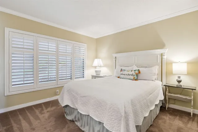 a bedroom with a bed a flat screen tv and a dresser