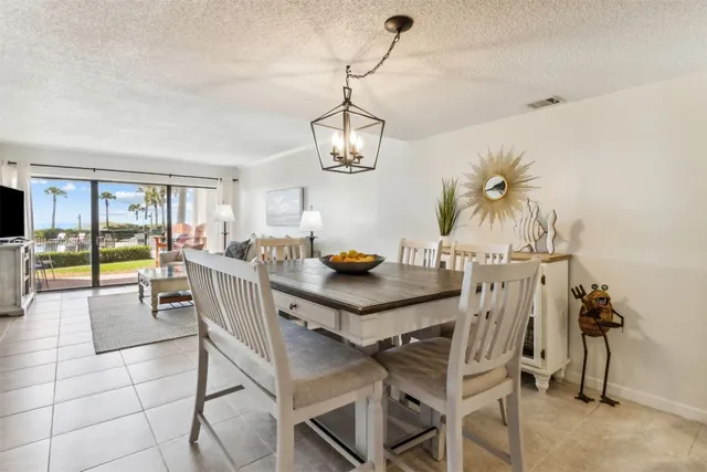 a view of a dining room with furniture a chandelier and wooden floor