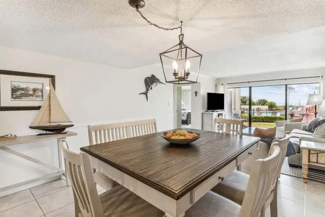 a view of a dining room and kitchen with furniture wooden floor and a chandelier