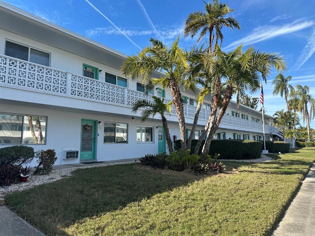 8450 112th Street North, Unit 102 Seminole, FL 33772 - Photo 2 of 80 a front view of a house with a yard