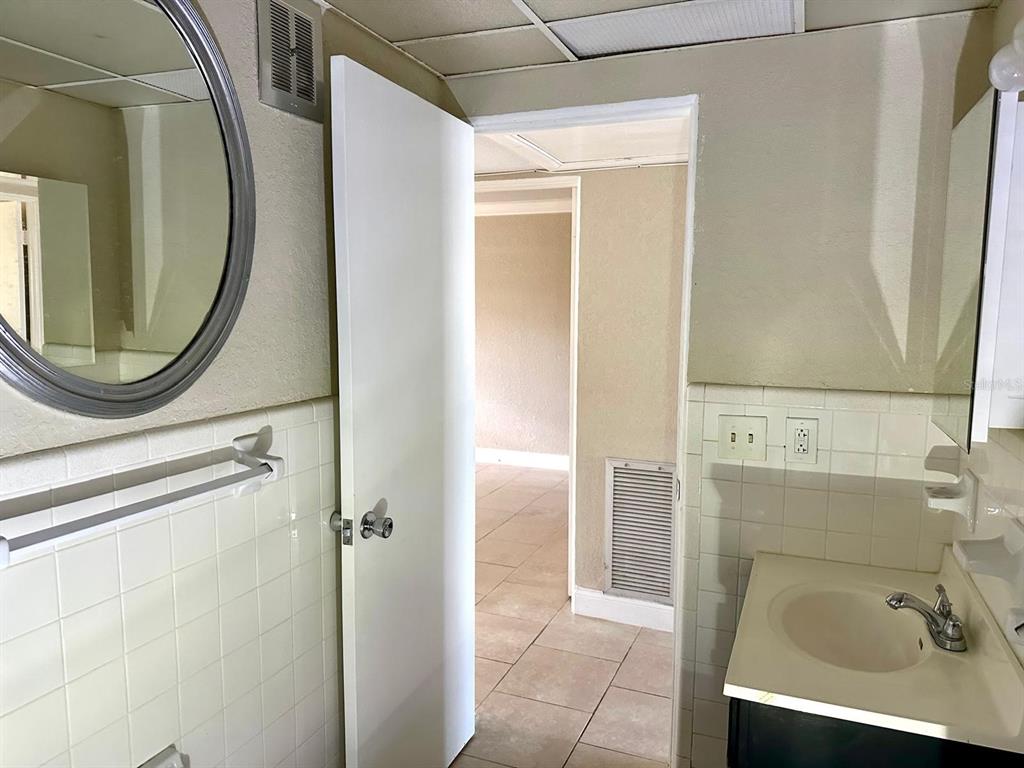 8450 112th Street North, Unit 102 Seminole, FL 33772 - Photo 30 of 80 a bathroom with a sink a mirror and a shower