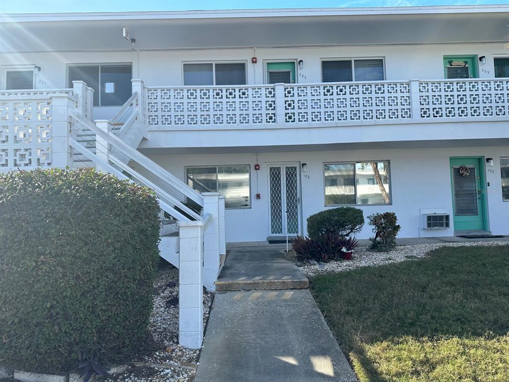 8450 112th Street North, Unit 102 Seminole, FL 33772 - Photo 3 of 80 a front view of a house with a yard