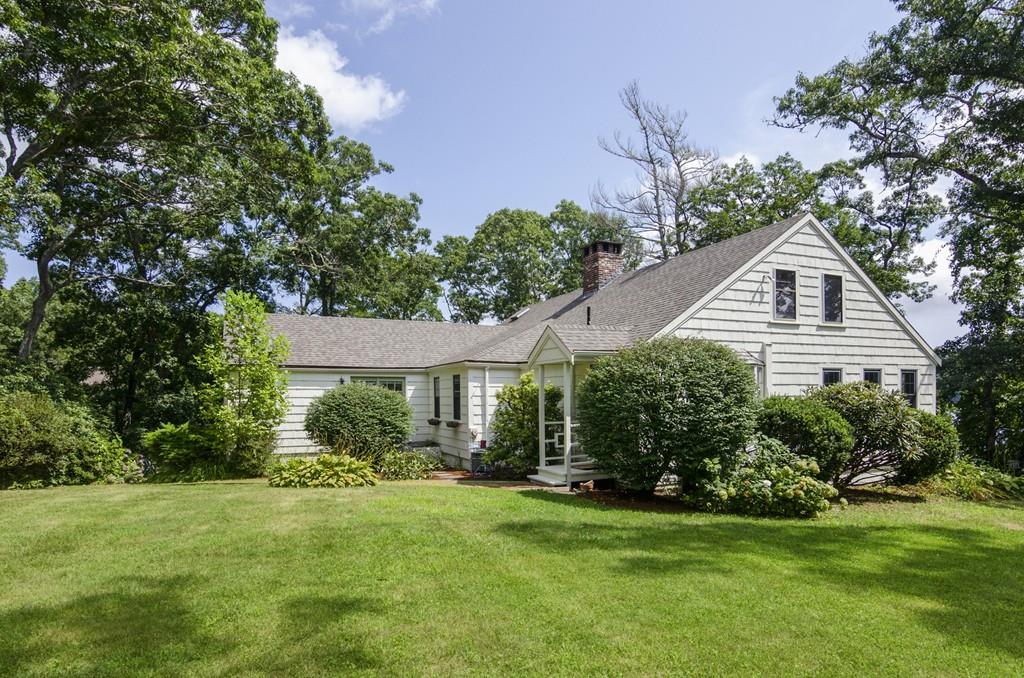 a front view of a house with a yard and green space