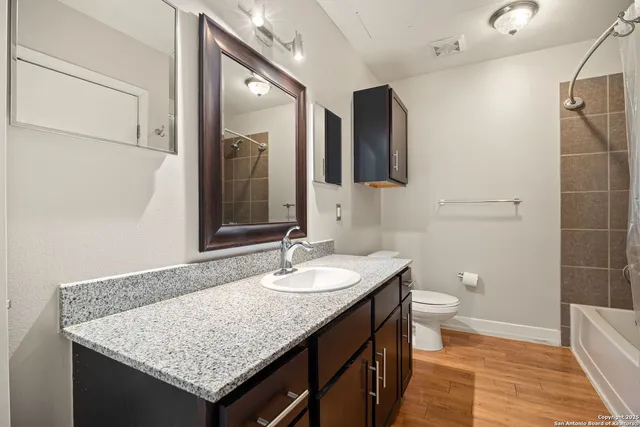 a bathroom with a granite countertop sink and a mirror