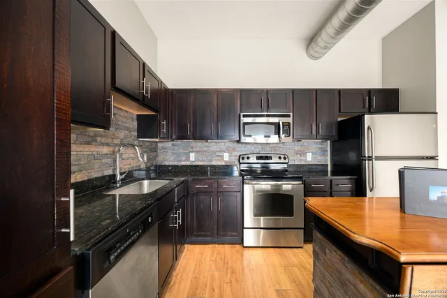 a kitchen with a sink stainless steel appliances and cabinets