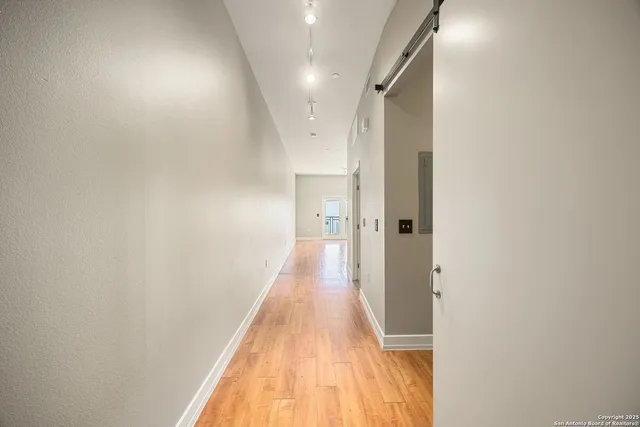 a view of a hallway with wooden floor
