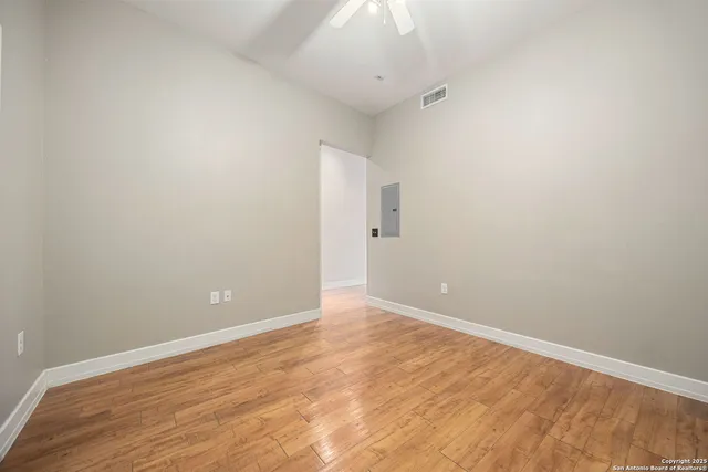 a view of an empty room with wooden floor