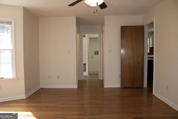 an empty room with wooden floor and window
