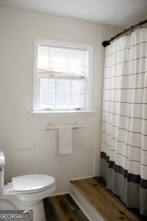 a bathroom with a sink toilet and window
