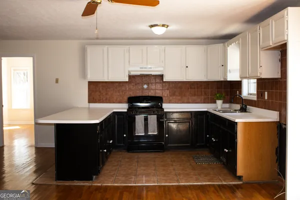 a kitchen with a sink cabinets and wooden floor