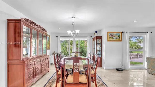 a large living room with stainless steel appliances granite countertop a couch and a large window