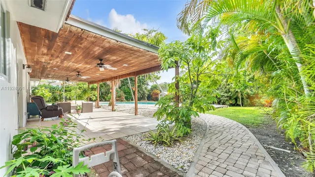 an aerial view of residential houses with outdoor space and trees