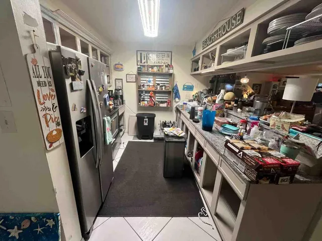 a view of a kitchen with fridge and rack
