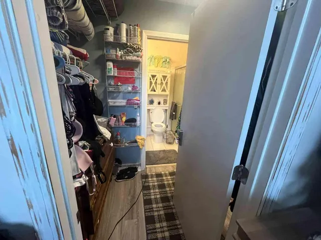 a view of walk in closet with clothes