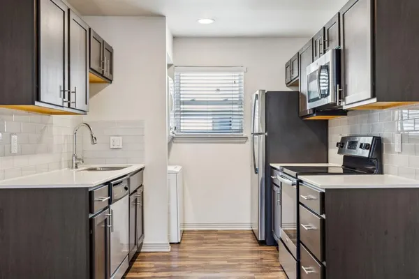 a kitchen with stainless steel appliances granite countertop a washer and dryer