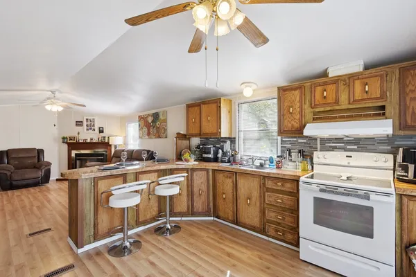 a kitchen with granite countertop a sink appliances cabinets and furniture