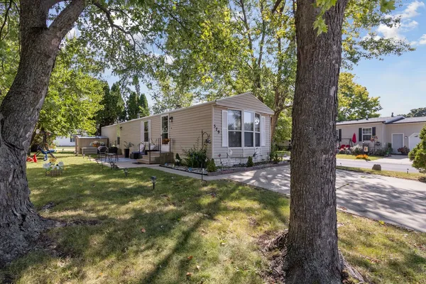 a view of a house with backyard and a tree