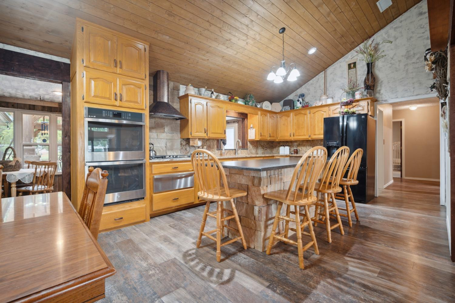 9002 Woodrow Road Wolfforth, TX 79382 - Photo 8 of 48 a dining room with stainless steel appliances kitchen island granite countertop a table chairs and a refrigerator