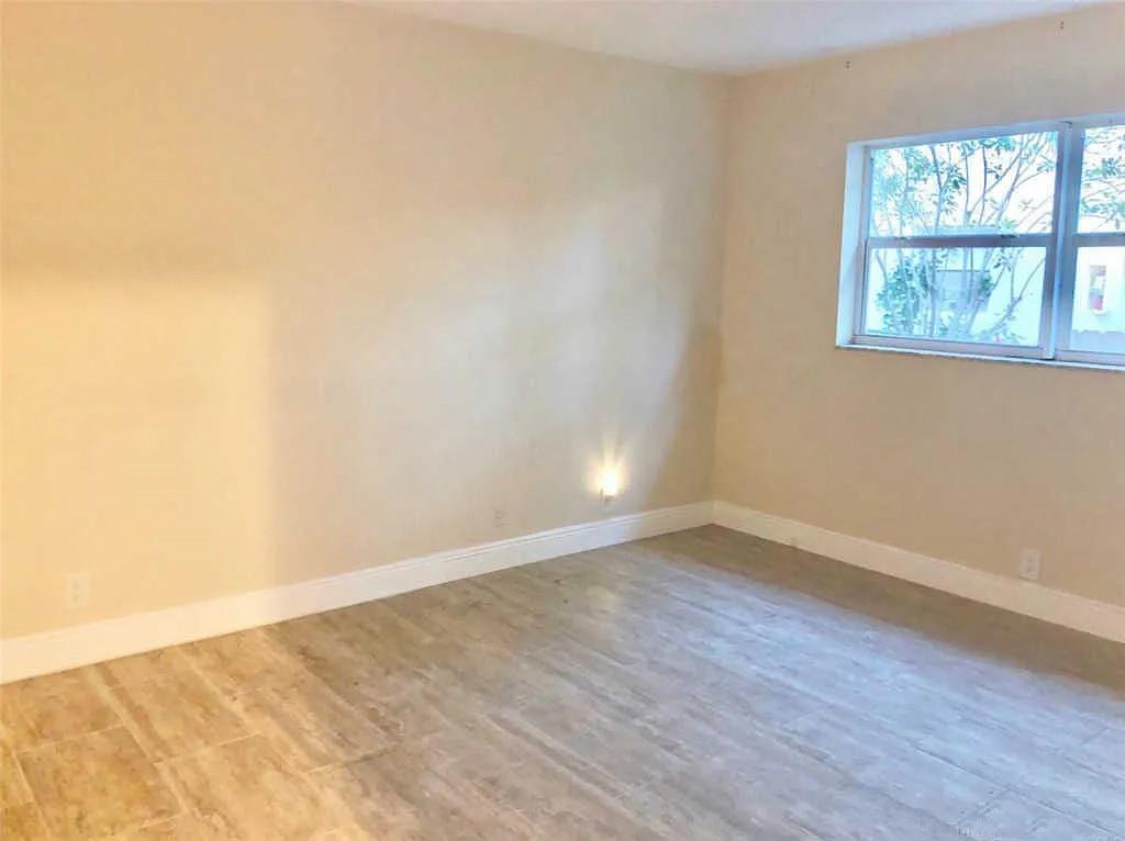 3502 Riverside Drive Coral Springs, FL 33065 - Photo 13 of 16 a view of an empty room with wooden floor and a window