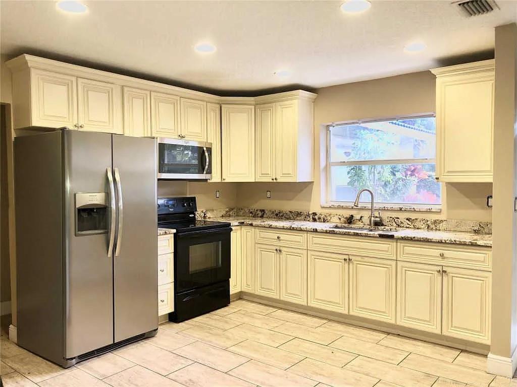 3502 Riverside Drive Coral Springs, FL 33065 - Photo 6 of 16 a kitchen with stainless steel appliances granite countertop a stove a sink and a refrigerator