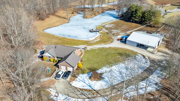 an aerial view of a house with swimming pool and outdoor seating