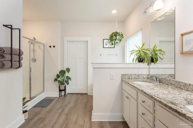a bathroom with a granite countertop sink a potted plant and a window