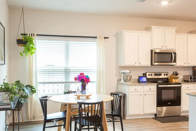 a kitchen with granite countertop white cabinets and white appliances