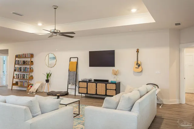 a living room with furniture a flat screen tv and a window