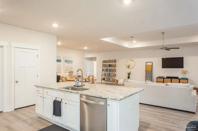 a kitchen with stainless steel appliances granite countertop a sink and a refrigerator