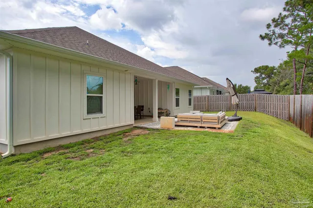 a view of a patio with table and chairs and potted plants with wooden fence