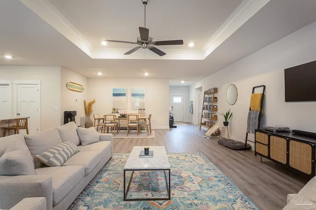 a living room with furniture a ceiling fan and a rug